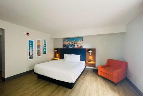 une chambre avec un lit et une chaise rouge dans l'établissement La Quinta by Wyndham Birmingham Homewood, à Birmingham