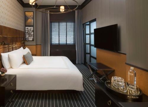 a hotel room with a bed and a flat screen tv at Gild Hall, A Thompson Hotel, by Hyatt in New York