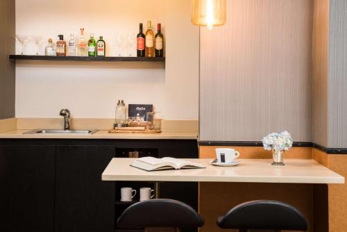a kitchen with a counter with two chairs and a sink at Gild Hall, A Thompson Hotel, by Hyatt in New York