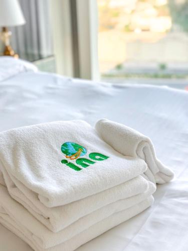 a pile of towels sitting on top of a bed at INA HOMES - 1BHK Downtown Views Direct Access to Dubai Mall in Dubai