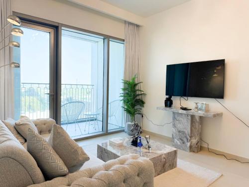 a living room with a couch and a flat screen tv at INA HOMES - 1BHK Downtown Views Direct Access to Dubai Mall in Dubai