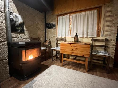 ein Zimmer mit einem Holzofen und einem Holzschreibtisch in der Unterkunft Apartamento Selva Blanca 9 in Villanúa