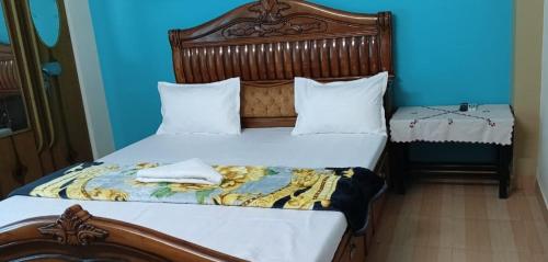 a bedroom with two beds and a blue wall at Goodluck Homestay in Guwahati