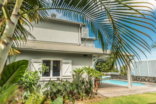 una casa con piscina delante en Villa meublé Tourisme 4 etoiles Sous le Ficus piscine chauffée - Ouest Lagon, en Saint-Paul