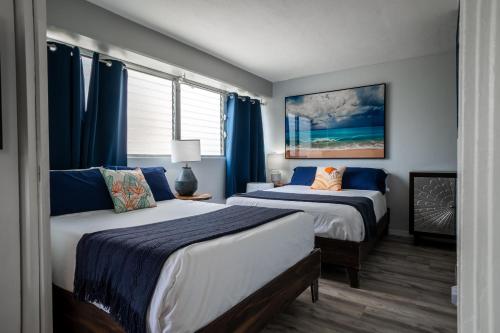 two beds in a room with blue drapes at Spacious 2 Bedroom, 1 bath Waikiki Condo in Honolulu