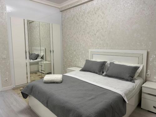 a bedroom with a large bed and a mirror at ЖК Керуен Сарай 5 in Türkistan