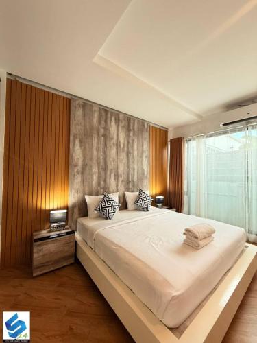 a large white bed in a room with a window at The S24 Resort Buriram in Buriram