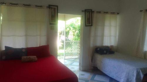 a bedroom with a bed and a door to a patio at T&T - Tatty and Tony Guesthouse in Negril