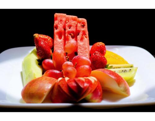 a plate of fruit on a white plate at Blooming Suites in Naivasha