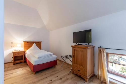 a bedroom with a bed and a flat screen tv at Apartments am Schloss Mühldorf in Feldkirchen an der Donau
