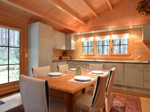 cocina con mesa de madera y sillas en Chalet in a peaceful location near Nijlen, en Nijlen