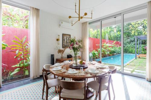 a dining room with a table and chairs and a pool at La Verona - 2,3,4 BHK Villas in Assagao with Private Pool, Garden, Caretaker, Kitchen & Security in Assagao