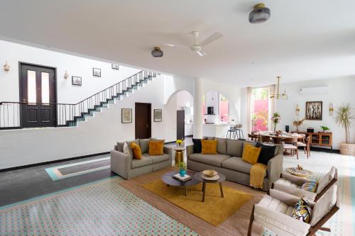 a living room with a couch and a table at La Verona - 2,3,4 BHK Villas in Assagao with Private Pool, Garden, Caretaker, Kitchen & Security in Assagao