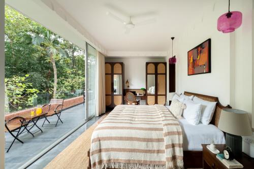 a bedroom with a bed and a balcony at La Verona - 2,3,4 BHK Villas in Assagao with Private Pool, Garden, Caretaker, Kitchen & Security in Assagao