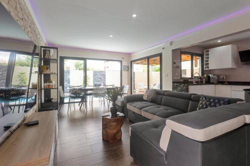 a living room with a couch and a table at Les Villas Jasmin Standing Piscine Chauffée Jacuzzi 5 Ch 14 Pers in Baie-Mahault