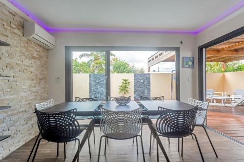 a dining room with a table and chairs at Les Villas Jasmin Standing Piscine Chauffée Jacuzzi 5 Ch 14 Pers in Baie-Mahault