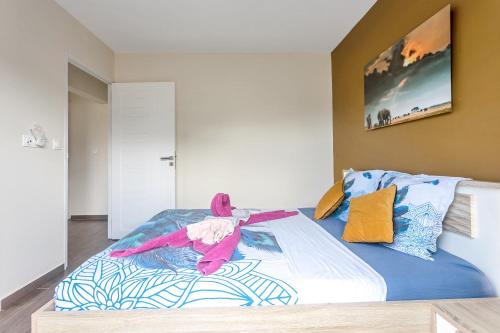 a bedroom with a large bed with colorful pillows at Les Villas Jasmin Standing Piscine Chauffée Jacuzzi 5 Ch 14 Pers in Baie-Mahault
