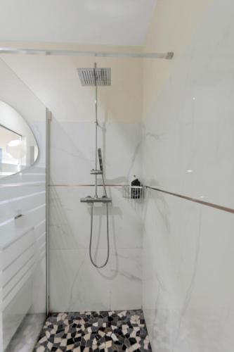 a bathroom with a shower with a black and white at Les Villas Jasmin Standing Piscine Chauffée Jacuzzi 5 Ch 14 Pers in Baie-Mahault