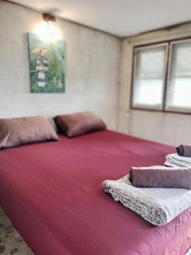 a large red bed with two pillows on top of it at Mountain Jungalows, Koh Chang in Trat