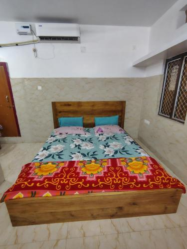 a bedroom with a bed with a colorful comforter at Gourinandan lodge in Puri