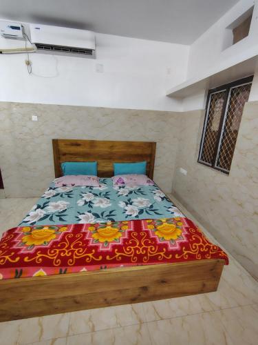 a bedroom with a bed with a colorful comforter at Gourinandan lodge in Puri