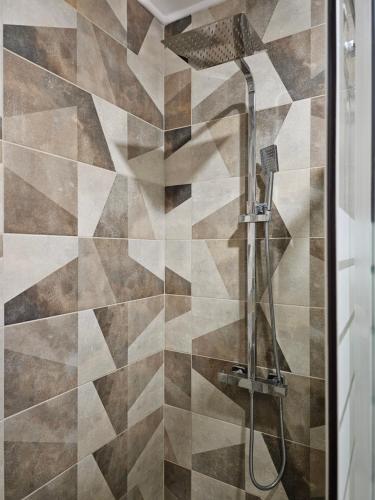 a shower with a shower head in a bathroom at Zerini Appartment in Burgas City