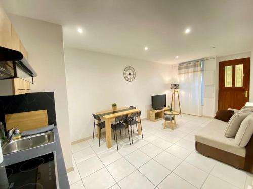 une cuisine et un salon avec une table et un canapé dans l'établissement Charmant T1 au Cœur de Nimes, à Nîmes