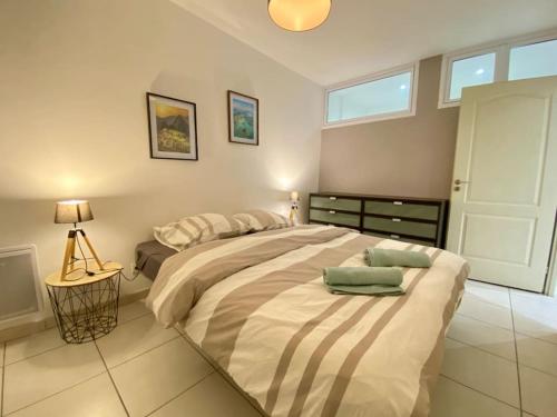 une chambre avec un grand lit avec deux oreillers dessus dans l'établissement Charmant T1 au Cœur de Nimes, à Nîmes