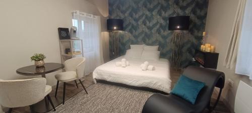 a bedroom with a bed and a table and chairs at Âme O des Flandres La Romantique in Boeschèpe
