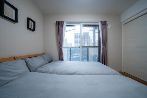 a bedroom with two beds and a window at Zabo Hills 305 in Sapporo