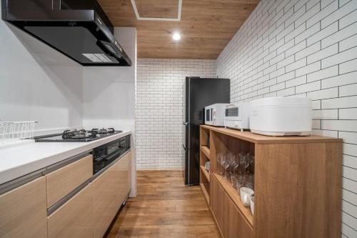 a kitchen with a stove and a refrigerator at Zabo Hills 305 in Sapporo