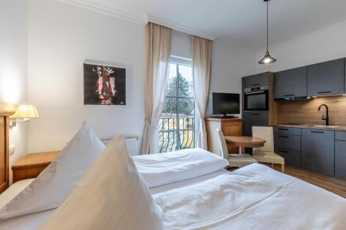 a hotel room with two beds and a kitchen at Apartments am Schloss Mühldorf in Feldkirchen an der Donau