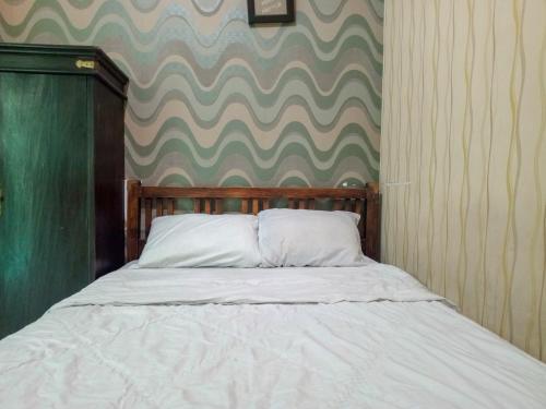 Ένα ή περισσότερα κρεβάτια σε δωμάτιο στο Trihakso Guest House near Kaliurang RedPartner