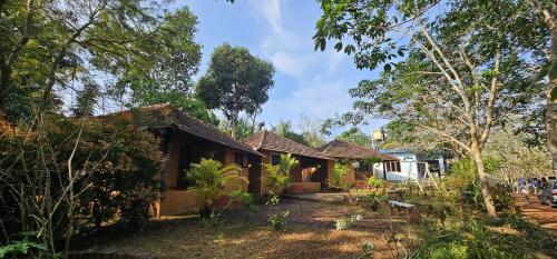 a house in the middle of a forest at Kudil Mud Cottages, Cheemeni in Peringom