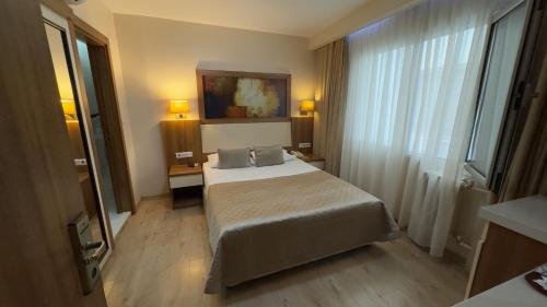 a hotel room with a bed and a window at Hotel Baylan İzmir in Izmir