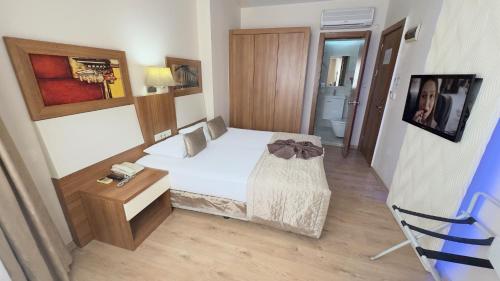 a small bedroom with a bed and a table at Hotel Baylan İzmir in Izmir
