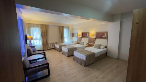 a large hotel room with two beds and a couch at Hotel Baylan İzmir in Izmir