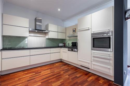 a kitchen with white appliances and wooden floors at Apartments am Schloss Mühldorf in Feldkirchen an der Donau