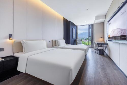 Ένα ή περισσότερα κρεβάτια σε δωμάτιο στο Atour Hotel Emeishan Railway Station Exiu Lake