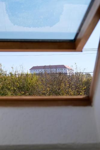 a view of a building through a window at Trón Apartman 2 in Siklós
