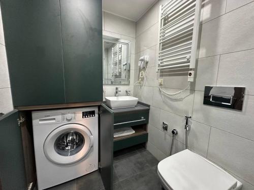 a bathroom with a washing machine and a sink at Beautiful apartments near the sea Adlia street in Batumi