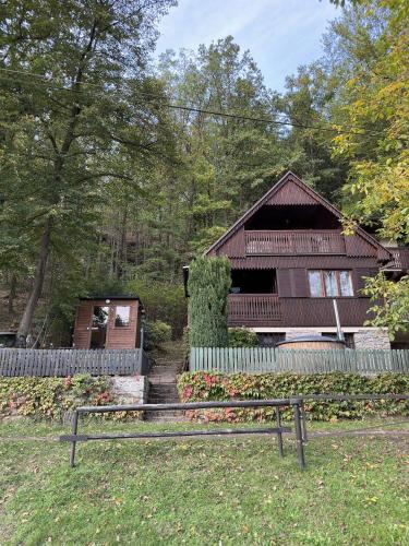a bench in front of a house with a fence at Rybaření ze sauny in Dobronice