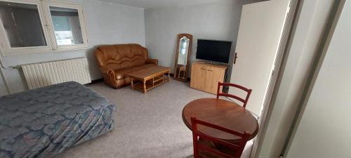 une chambre avec un lit, une chaise et une télévision dans l'établissement Beau studio, à Châteauroux