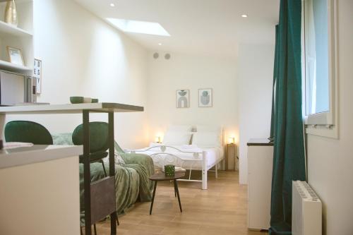 une chambre blanche avec un lit et une table dans l'établissement Penbed - Montparnasse 2 - Studio, à Paris