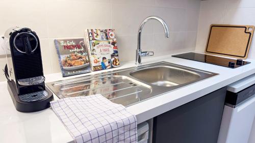 un comptoir de cuisine avec un évier et un micro-ondes dans l'établissement Penbed - Montparnasse 2 - Studio, à Paris