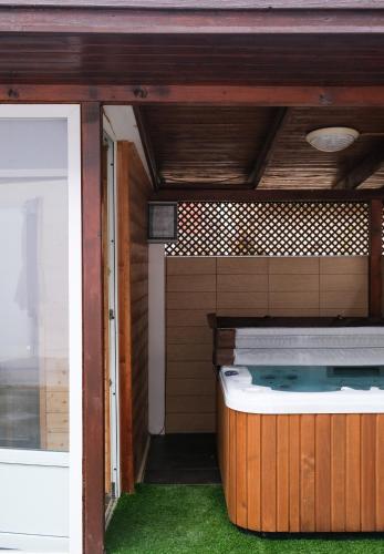 a porch with a hot tub in a house at Trón Apartman 2 in Siklós