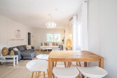 a living room with a table and white chairs at Cayo Coco Yodo - 2 min walk to the beach in Torreguadiaro