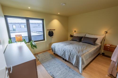 a bedroom with a bed and a large window at Town house with good view on top of Tromsø Island in Tromsø
