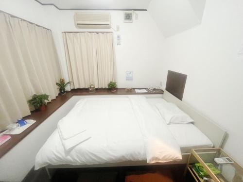 a bedroom with a large bed with white sheets at Jl千住別荘 in Tokyo