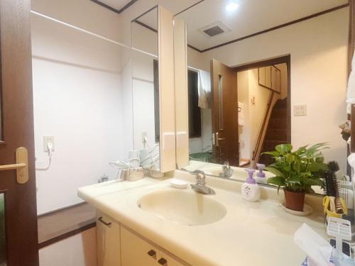 a bathroom with a sink and a large mirror at Jl千住別荘 in Tokyo